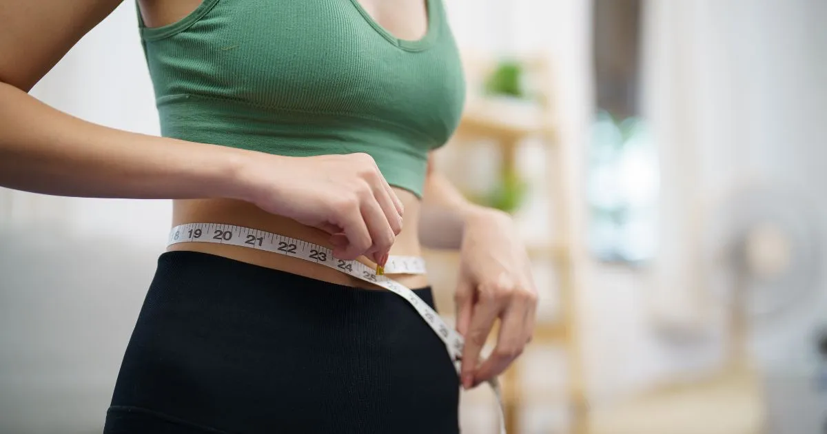 Woman measuring waist for medical weight loss results in Coral Springs, FL